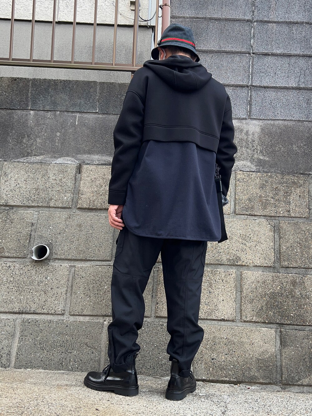 ブラック系のカーゴパンツ、ブラック系のブーツ、ブラック系のショルダーバッグを着用したメンズの秋コーディネートの2枚目の写真