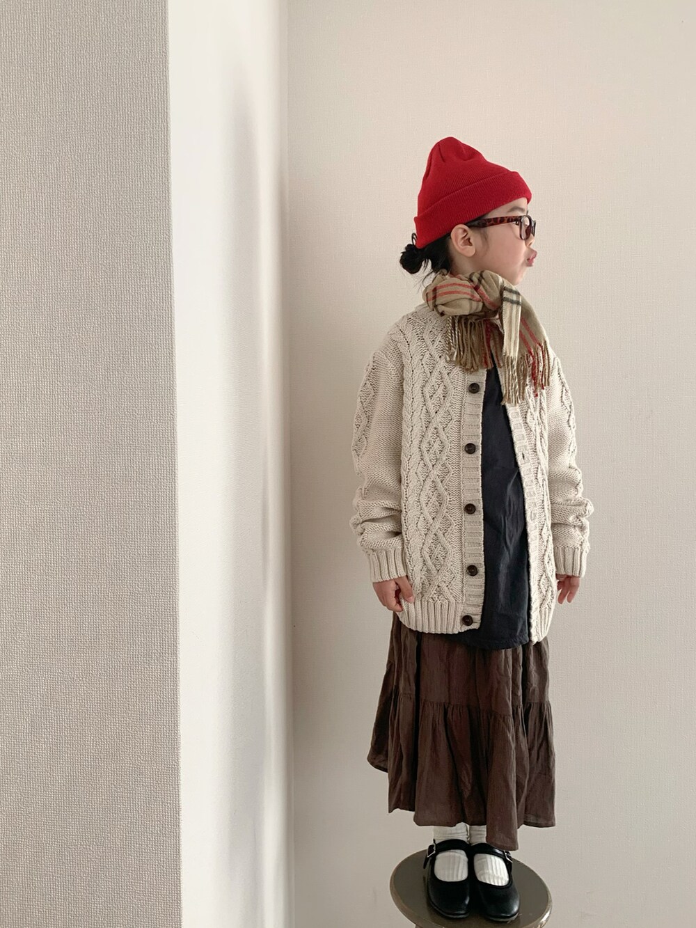 ブラウン系のスカート、ブラック系のバレエシューズを着用したキッズの冬コーディネートの2枚目の写真