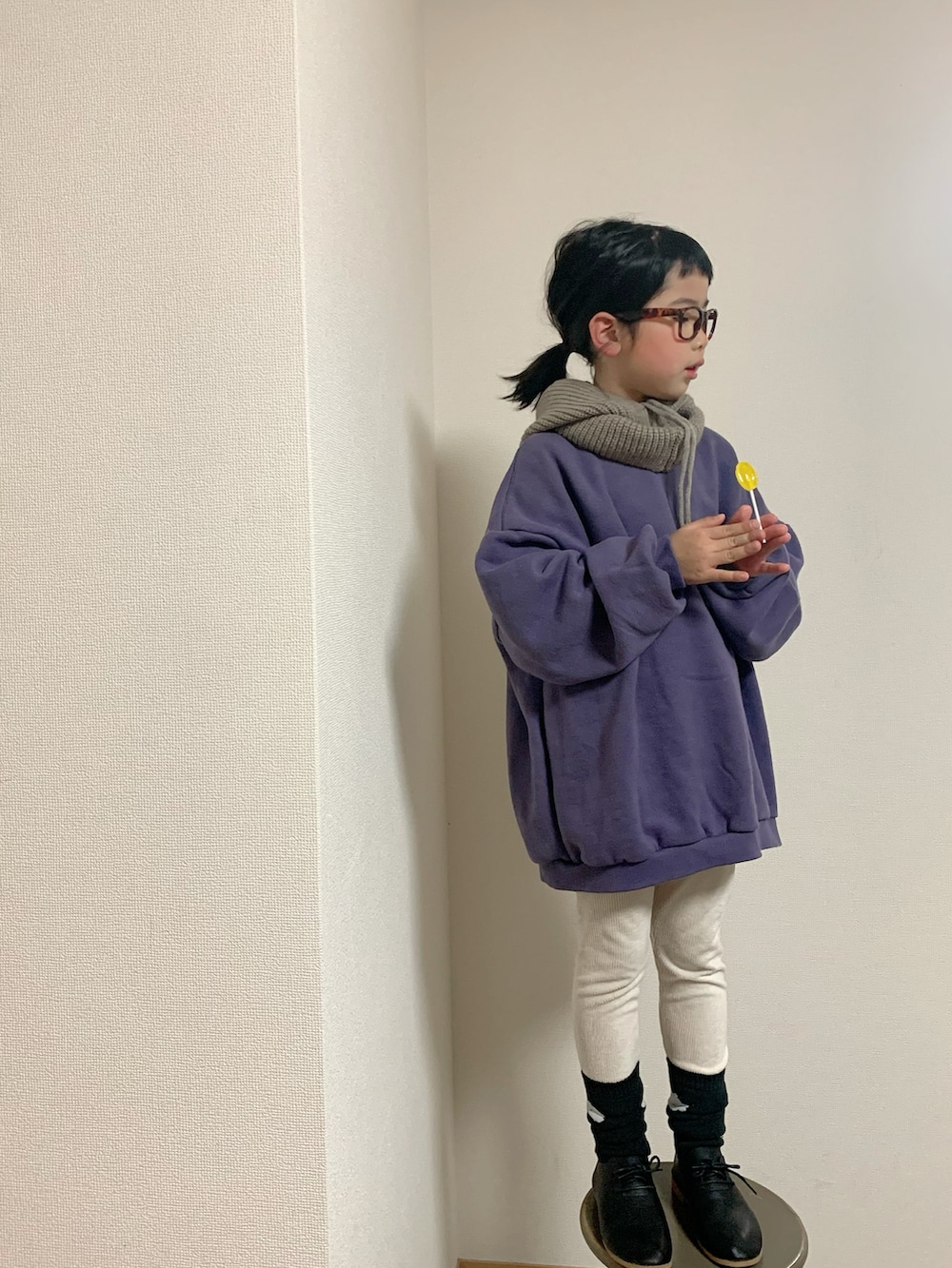 パープル系のスウェット、ブラック系のシューズ、ホワイト系のレッグウェアを着用したキッズの冬コーディネートの2枚目の写真