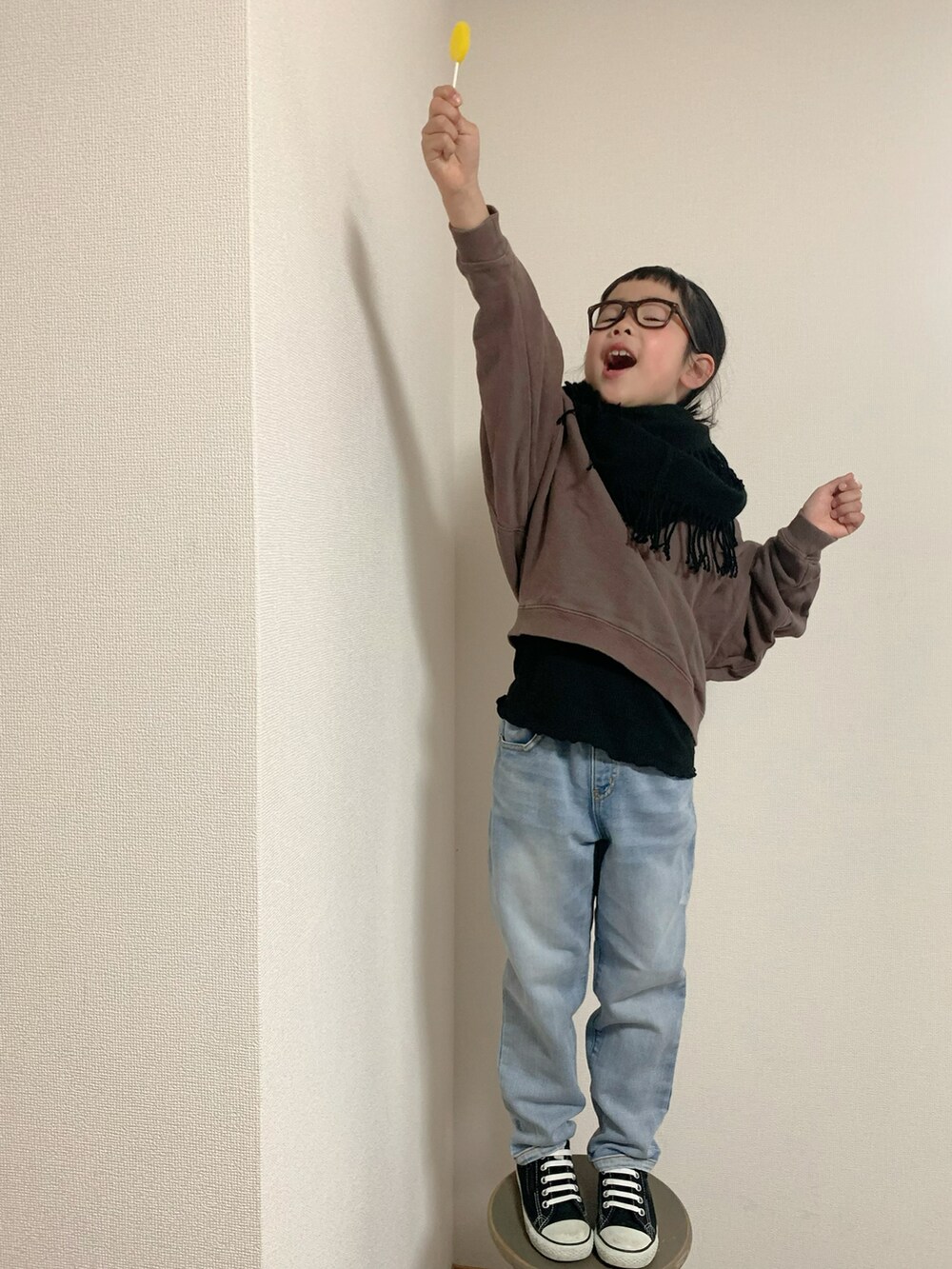 ブルー系のデニムパンツ、ブラック系のスニーカー、ブラウン系のトップスを着用したキッズの冬コーディネートの2枚目の写真