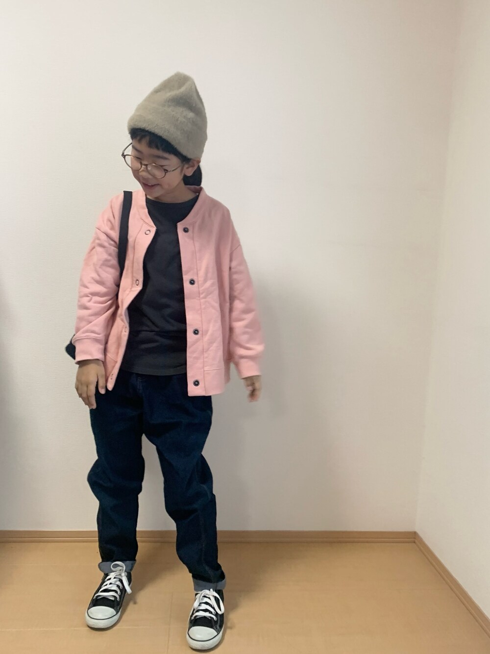 ブラック系のスニーカー、ブラック系のショルダーバッグ、ブルー系のデニムパンツを着用したキッズの秋コーディネートの3枚目の写真