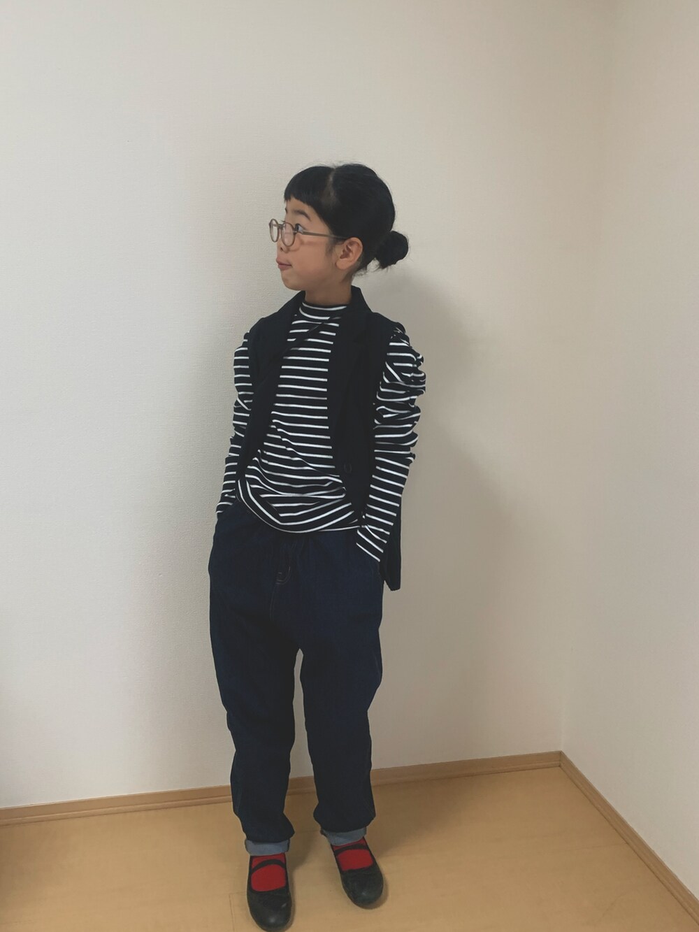 ブラック系のTシャツ/カットソー、ブルー系のデニムパンツ、ブラック系のベストを着用したキッズの秋コーディネートの2枚目の写真