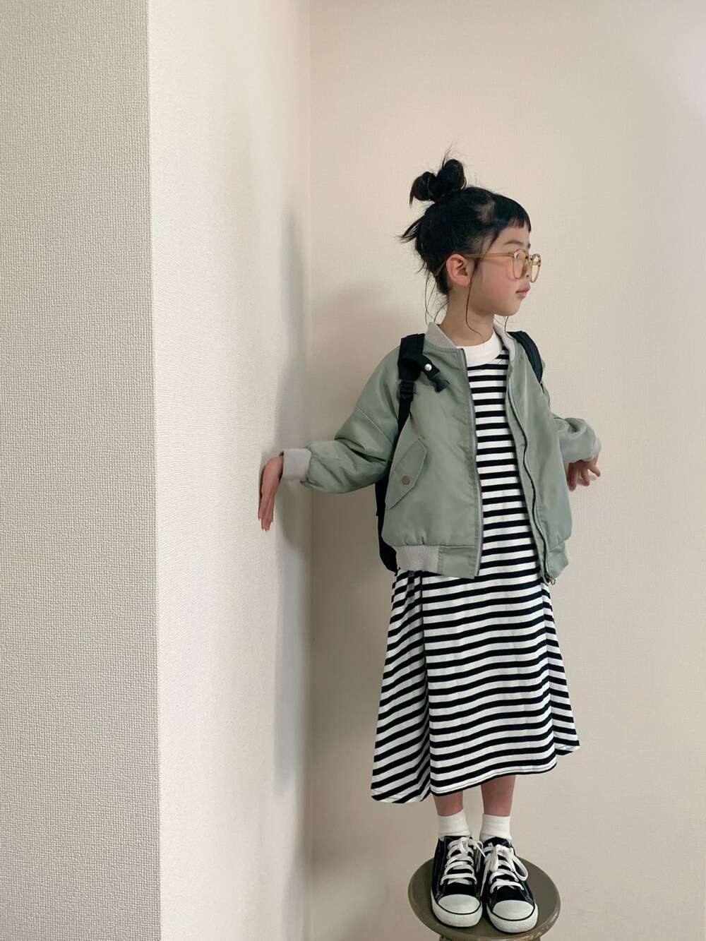 ブラック系のスニーカー、ホワイト系のワンピース/ドレス、グリーン系のMA-1を着用したキッズの春コーディネートの2枚目の写真