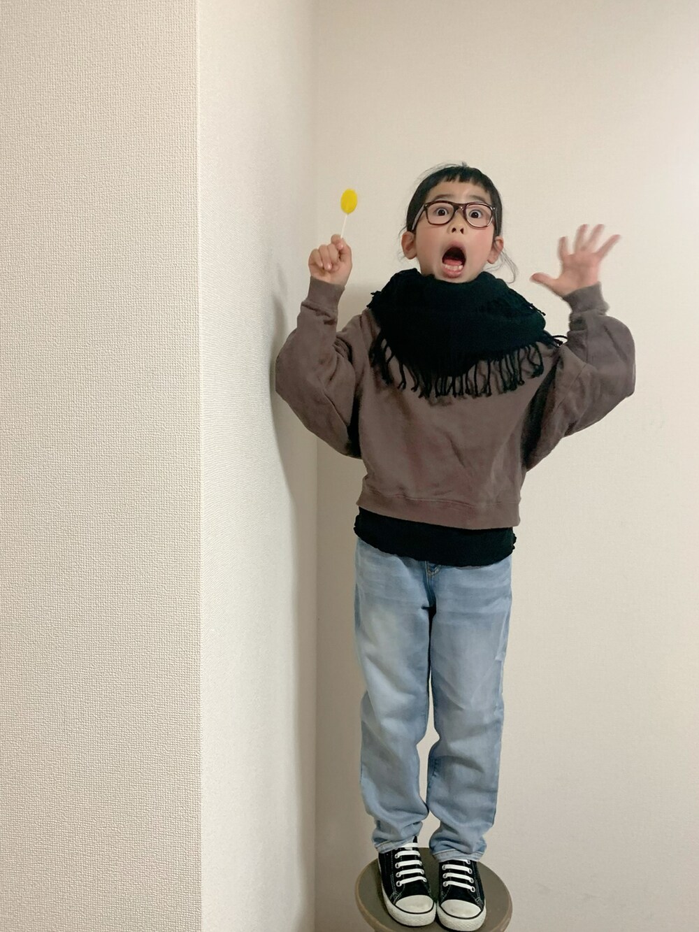 ブルー系のデニムパンツ、ブラック系のスニーカー、ブラウン系のトップスを着用したキッズの冬コーディネートの3枚目の写真