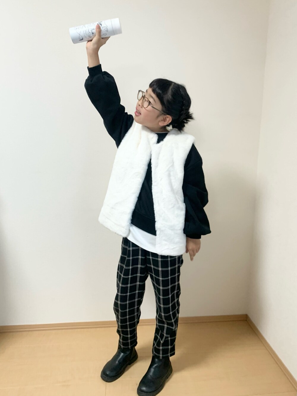 ブラック系のパンツ、ホワイト系のベスト、ブラック系のスウェットを着用したキッズの秋コーディネートの2枚目の写真