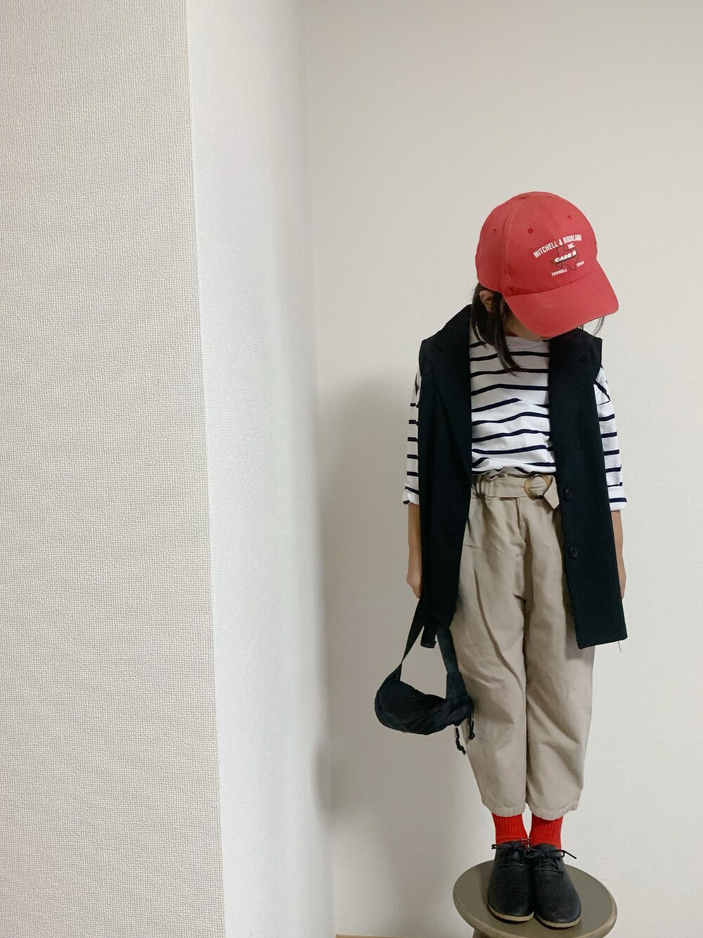 ブラック系のシューズ、ブラック系のボディバッグ/ウエストポーチ、ベージュ系のパンツを着用したキッズの秋コーディネートの2枚目の写真