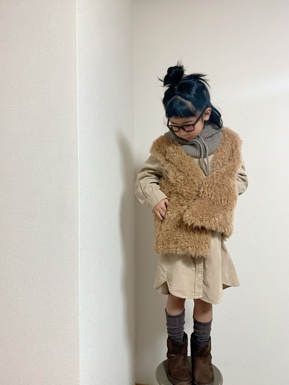 イエロー系のベスト、ベージュ系のワンピース/ドレス、ベージュ系のハットを着用したキッズの冬コーディネートの2枚目の写真