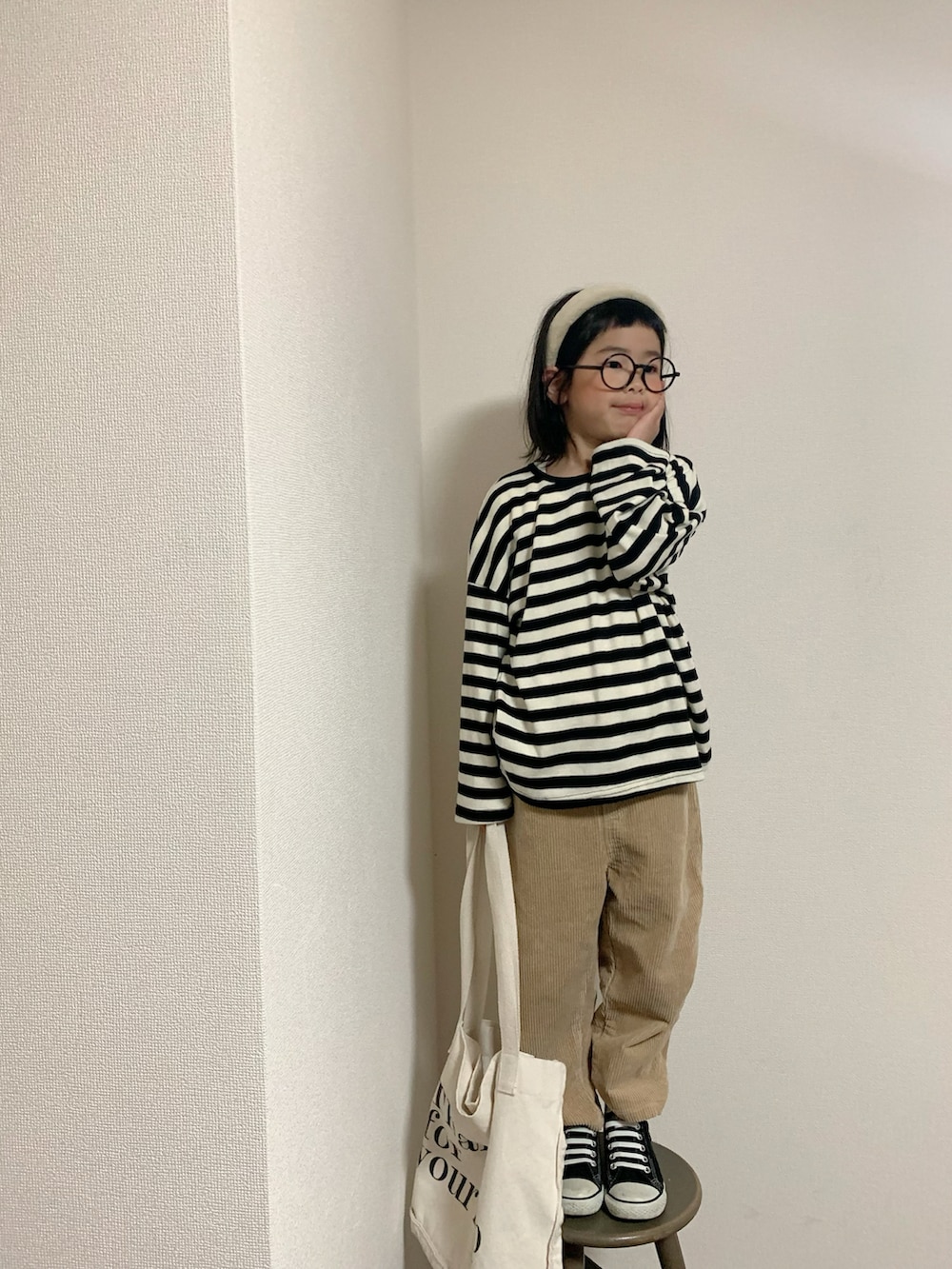 ベージュ系のパンツ、ブラック系のスニーカー、ベージュ系のカチューシャを着用したキッズの冬コーディネートの2枚目の写真