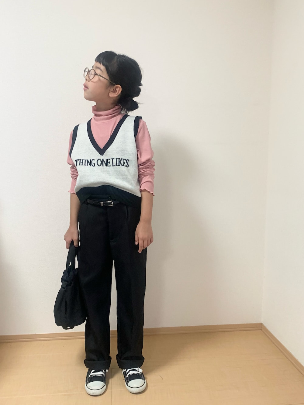 ピンク系のTシャツ/カットソー、ホワイト系のベスト、ブラック系のスニーカーを着用したキッズの秋コーディネートの2枚目の写真