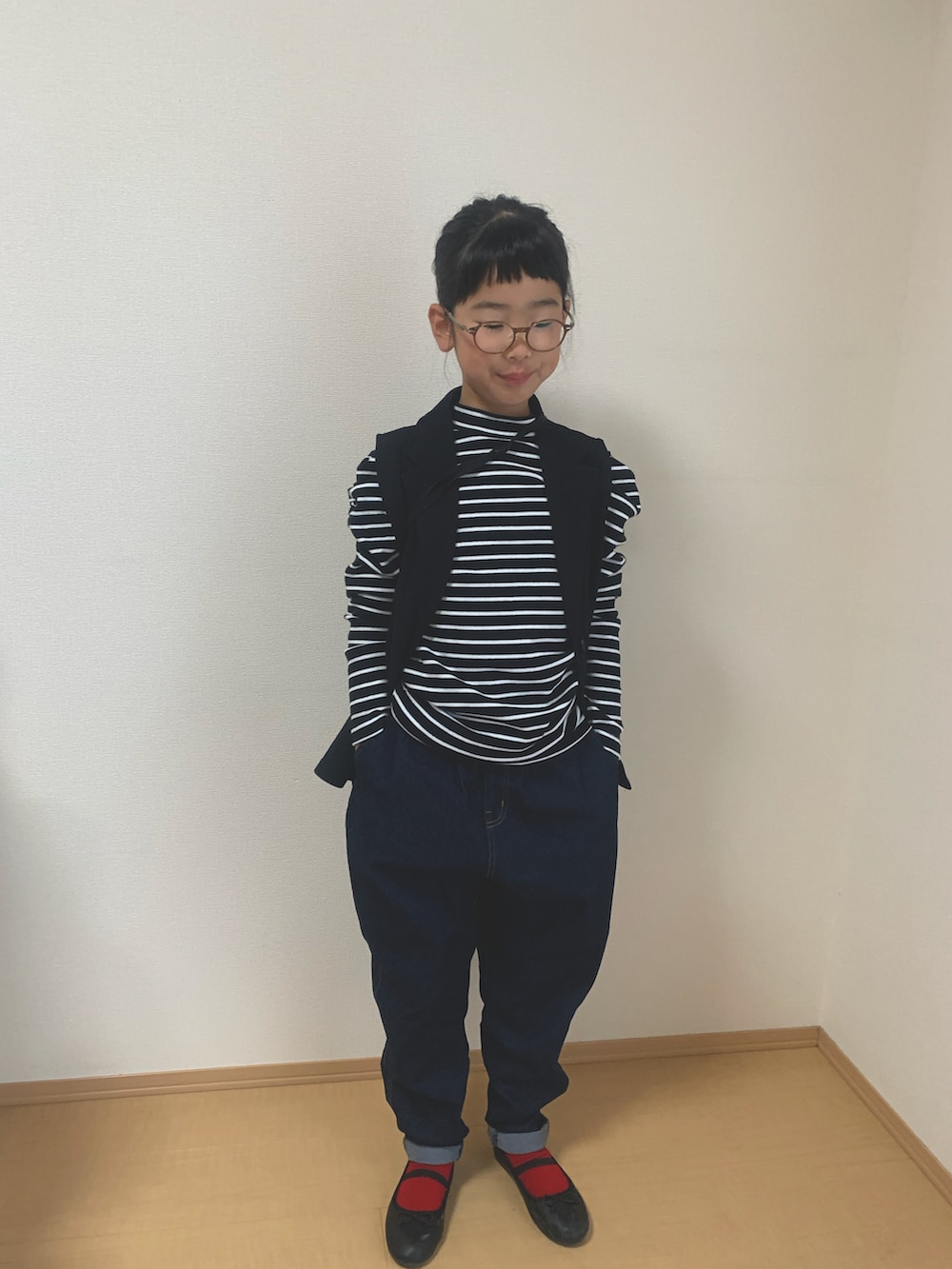 ブラック系のTシャツ/カットソー、ブルー系のデニムパンツ、ブラック系のベストを着用したキッズの秋コーディネートの3枚目の写真