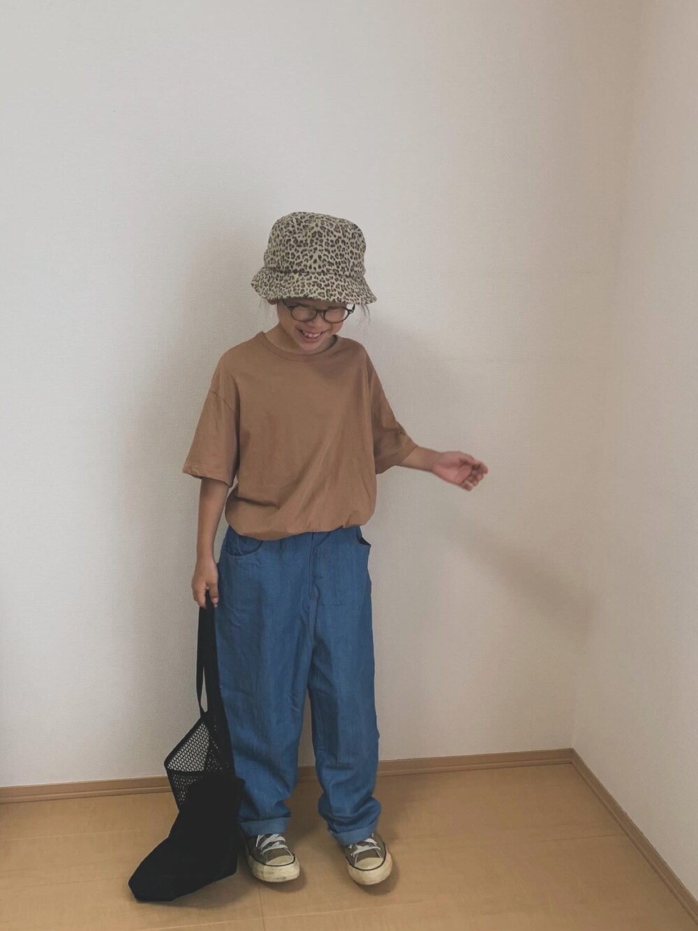 ベージュ系のスニーカー、ブルー系のデニムパンツ、ブラック系のトートバッグを着用したキッズの夏コーディネートの2枚目の写真
