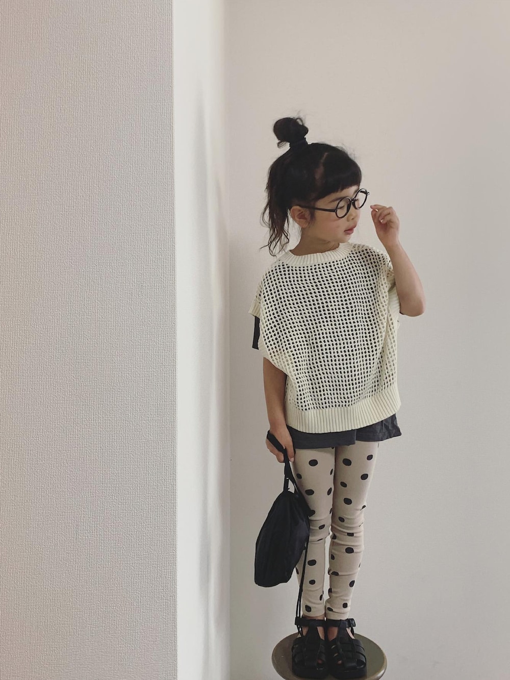 ブラック系のサンダル、ホワイト系のベスト、グレー系のTシャツ/カットソーを着用したキッズの春コーディネートの2枚目の写真