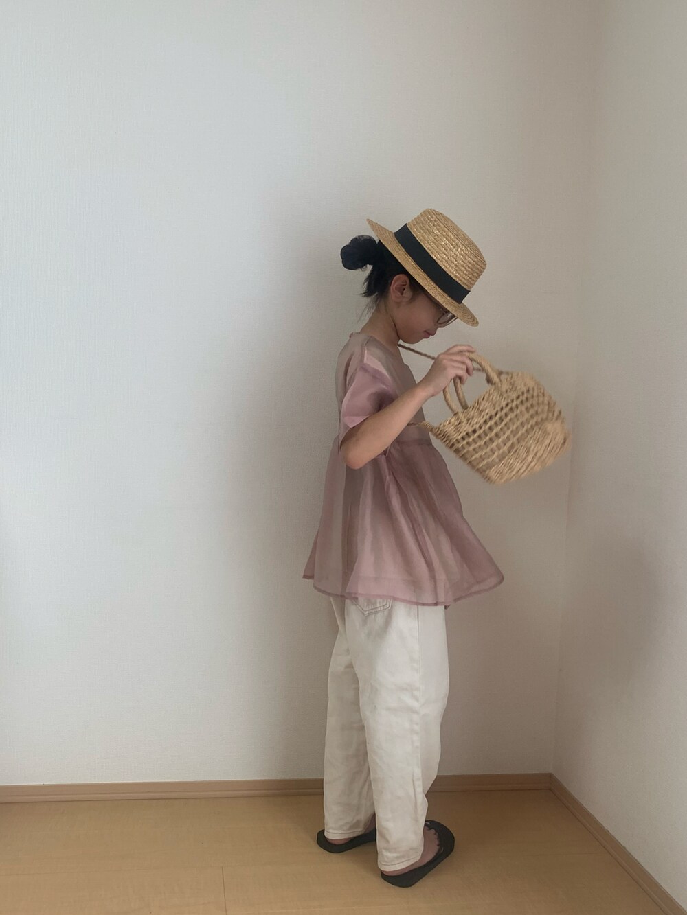 ホワイト系のデニムパンツ、ブラック系のサンダル、ピンク系のシャツ/ブラウスを着用したキッズの夏コーディネートの2枚目の写真