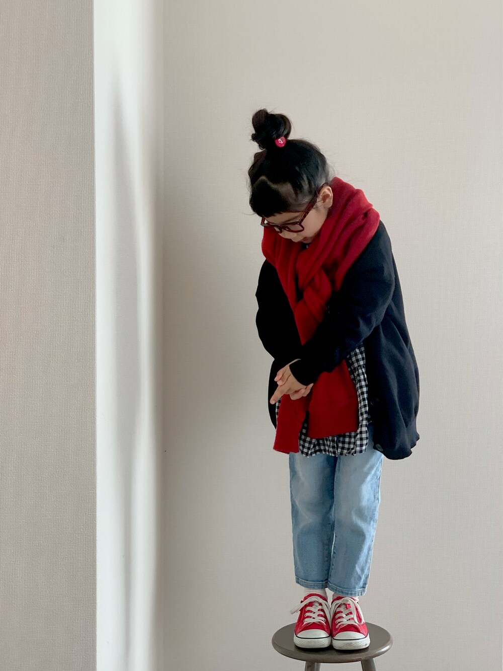 ブルー系のデニムパンツ、レッド系のスニーカー、ブラック系のカーディガン/ボレロを着用したキッズの冬コーディネートの2枚目の写真