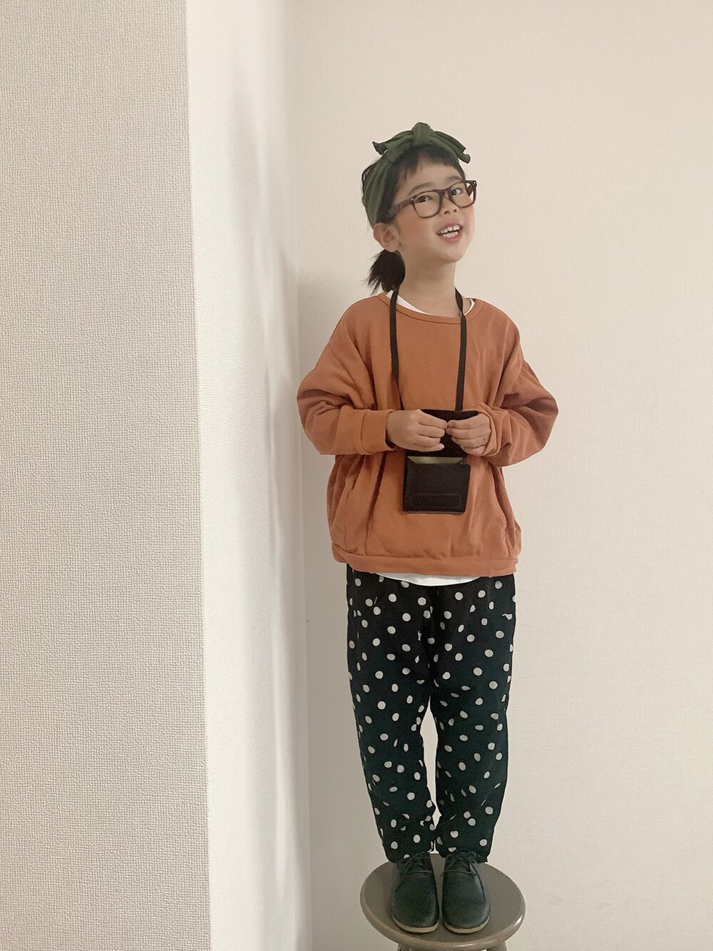 ブラック系のその他パンツ、ブラック系のシューズ、ブラック系のショルダーバッグを着用したキッズの秋コーディネートの2枚目の写真