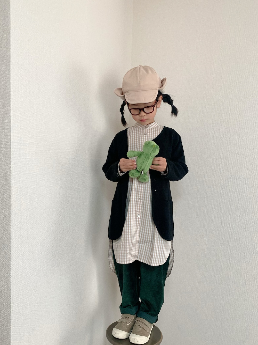 ベージュ系のスニーカー、ブラック系のニット/セーター、ベージュ系のシャツ/ブラウスを着用したキッズの冬コーディネートの3枚目の写真