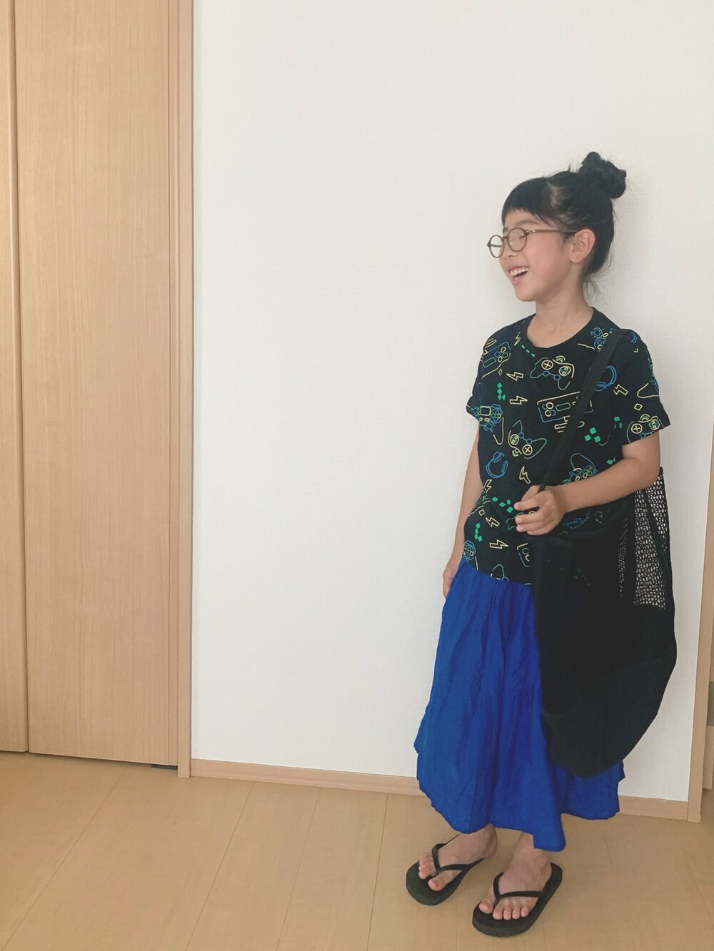 ブラック系のサンダル、ブラック系のトートバッグ、ブラック系のTシャツ/カットソーを着用したキッズの夏コーディネートの2枚目の写真