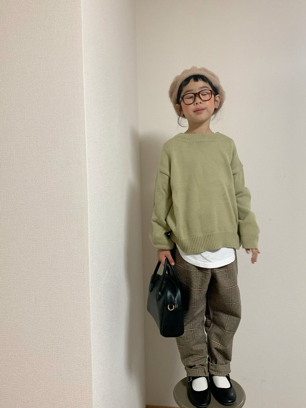 ブラウン系のパンツ、ブラック系のバッグ、ブラック系のバレエシューズを着用したキッズの冬コーディネートの2枚目の写真