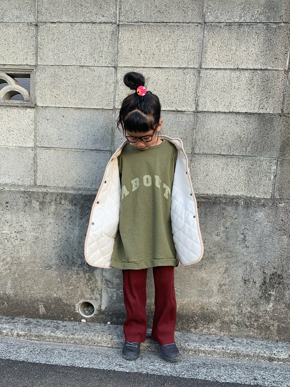 ブラック系のスニーカー、レッド系のその他パンツ、ベージュ系のジャケット/アウターを着用したキッズの冬コーディネートの2枚目の写真