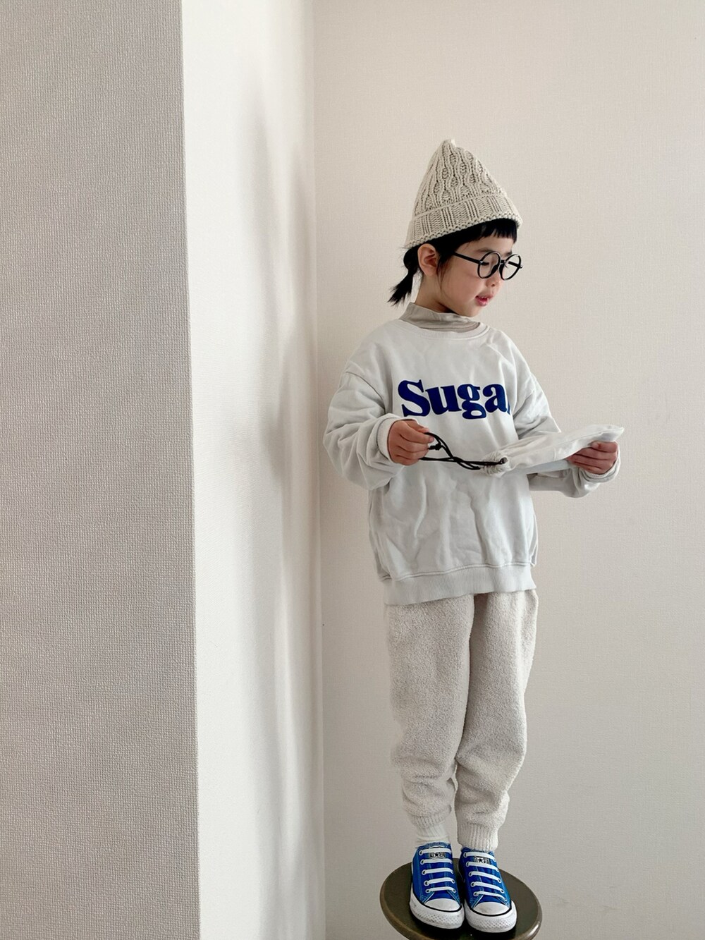 ホワイト系のスウェット、ホワイト系のパンツ、ブルー系のスニーカーを着用したキッズの冬コーディネートの2枚目の写真