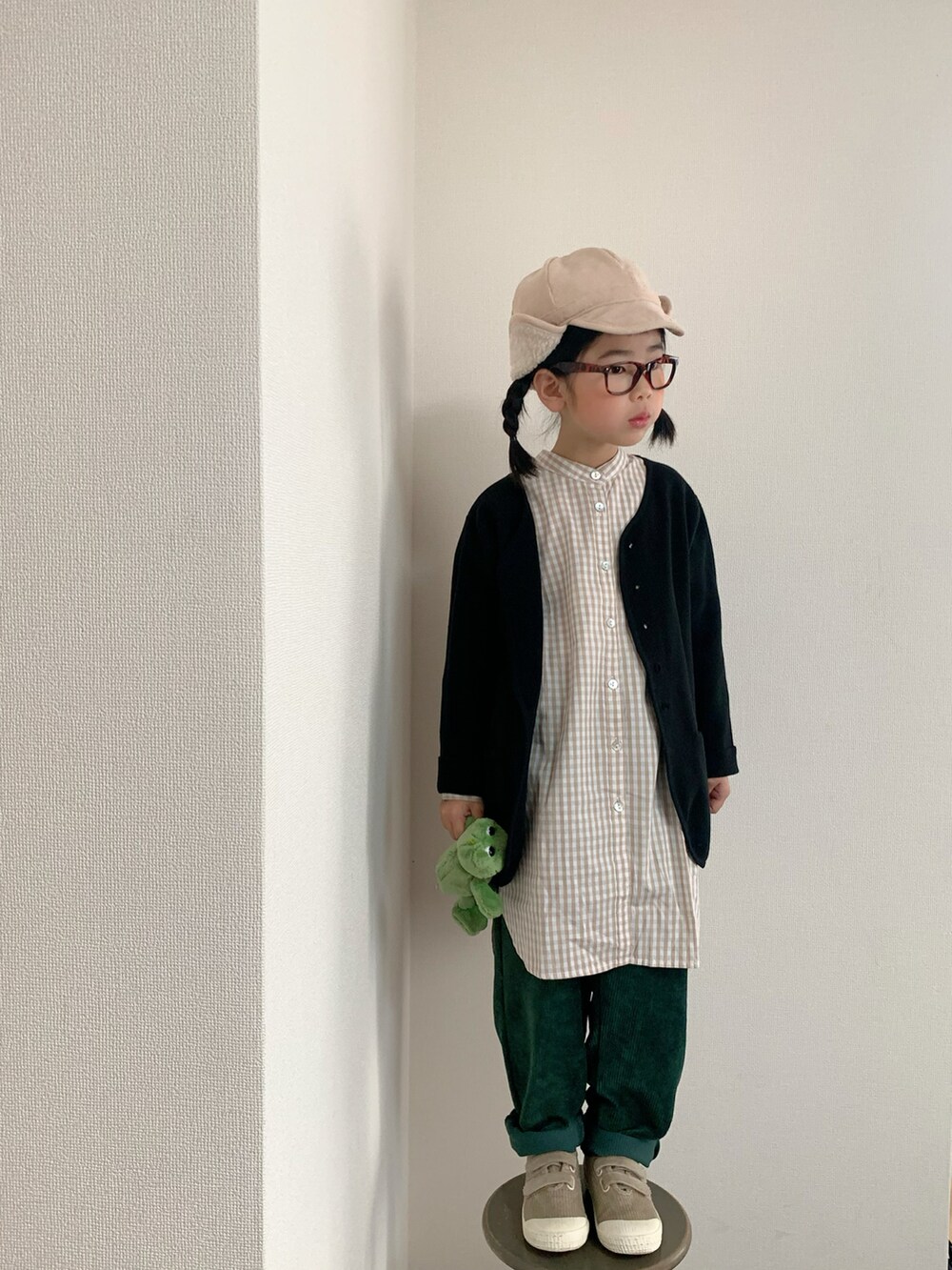 ベージュ系のスニーカー、ブラック系のニット/セーター、ベージュ系のシャツ/ブラウスを着用したキッズの冬コーディネートの2枚目の写真