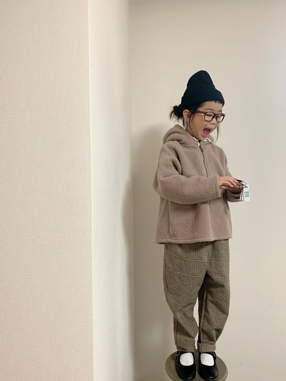 ブラウン系のパンツ、ブラック系のバレエシューズを着用したキッズの冬コーディネートの2枚目の写真