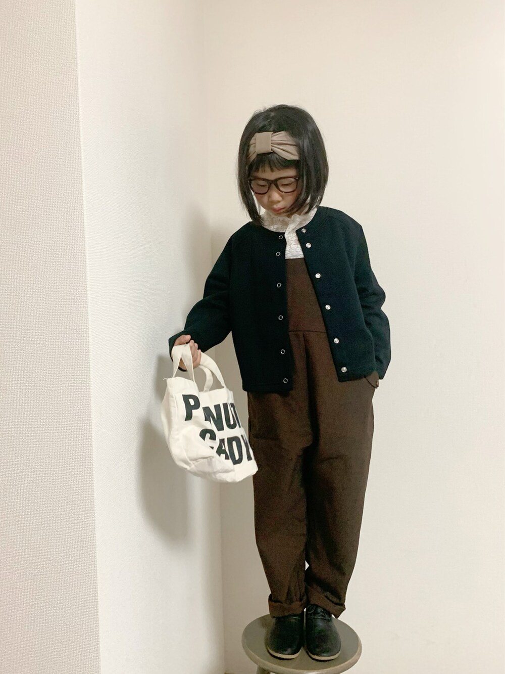 ブラック系のシューズ、ブラウン系のサロペット/オーバーオール、ブラック系のカーディガン/ボレロを着用したキッズの秋コーディネートの2枚目の写真