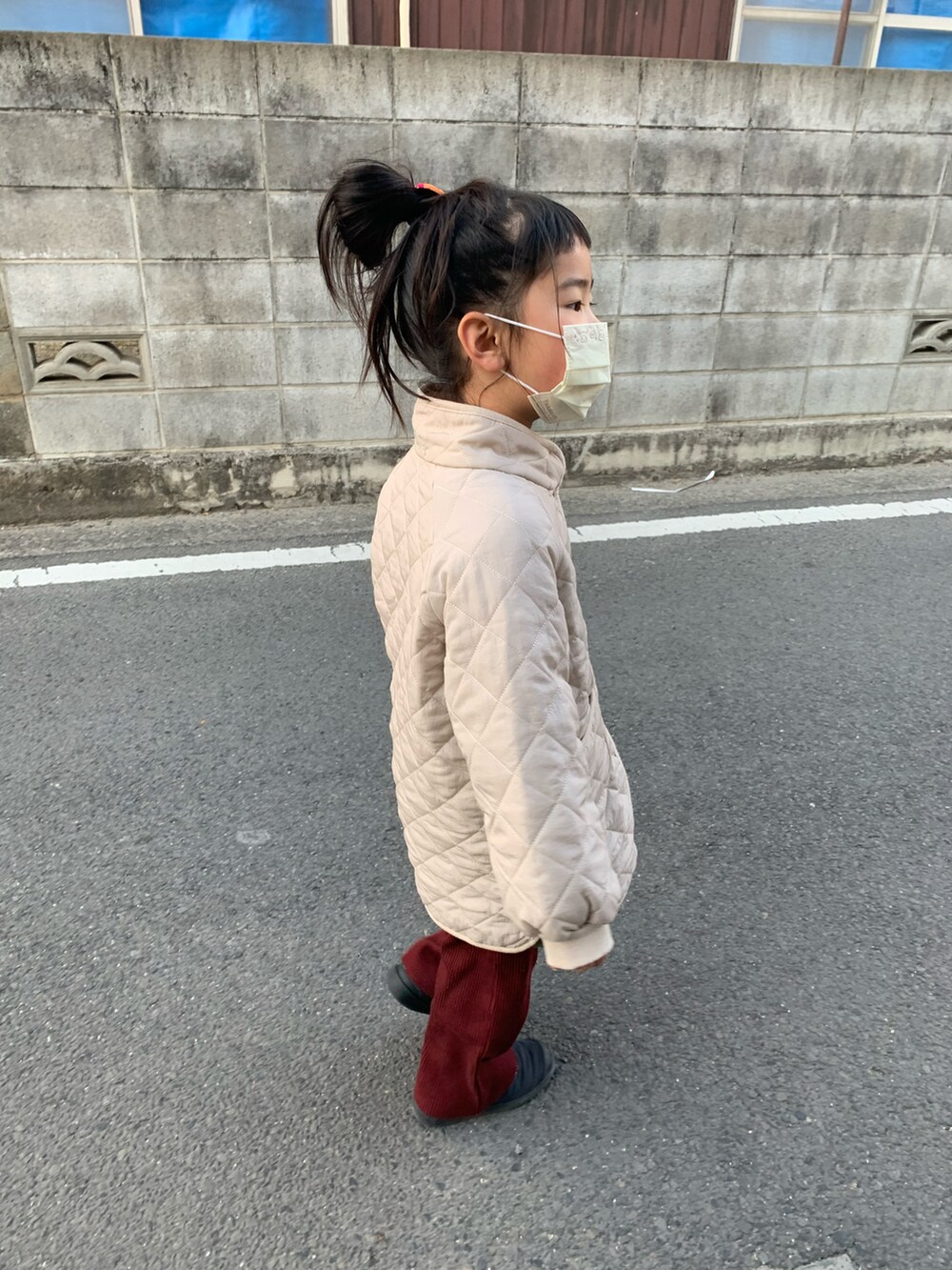 ブラック系のスニーカー、レッド系のその他パンツ、ベージュ系のジャケット/アウターを着用したキッズの冬コーディネートの3枚目の写真