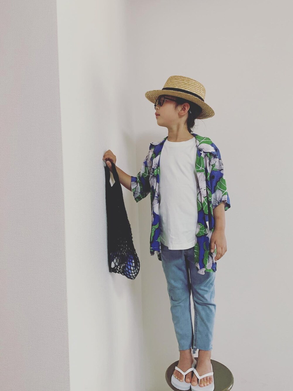 ブルー系のデニムパンツ、ホワイト系のサンダル、ホワイト系のタンクトップを着用したキッズの夏コーディネートの2枚目の写真