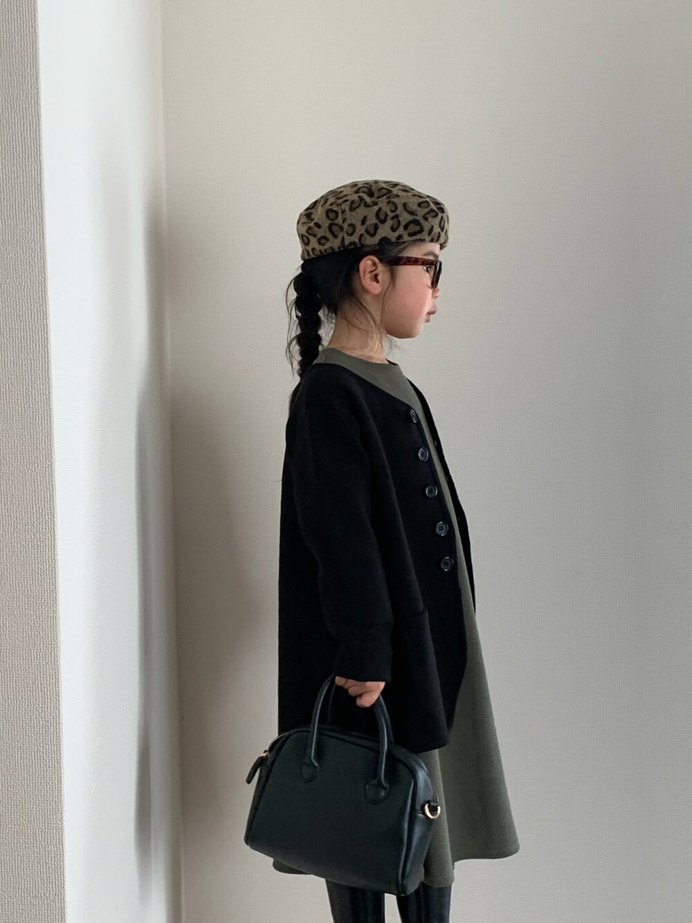 ブラック系のバッグ、ブラック系のブーツ、グリーン系のTシャツ/カットソーを着用したキッズの冬コーディネートの2枚目の写真