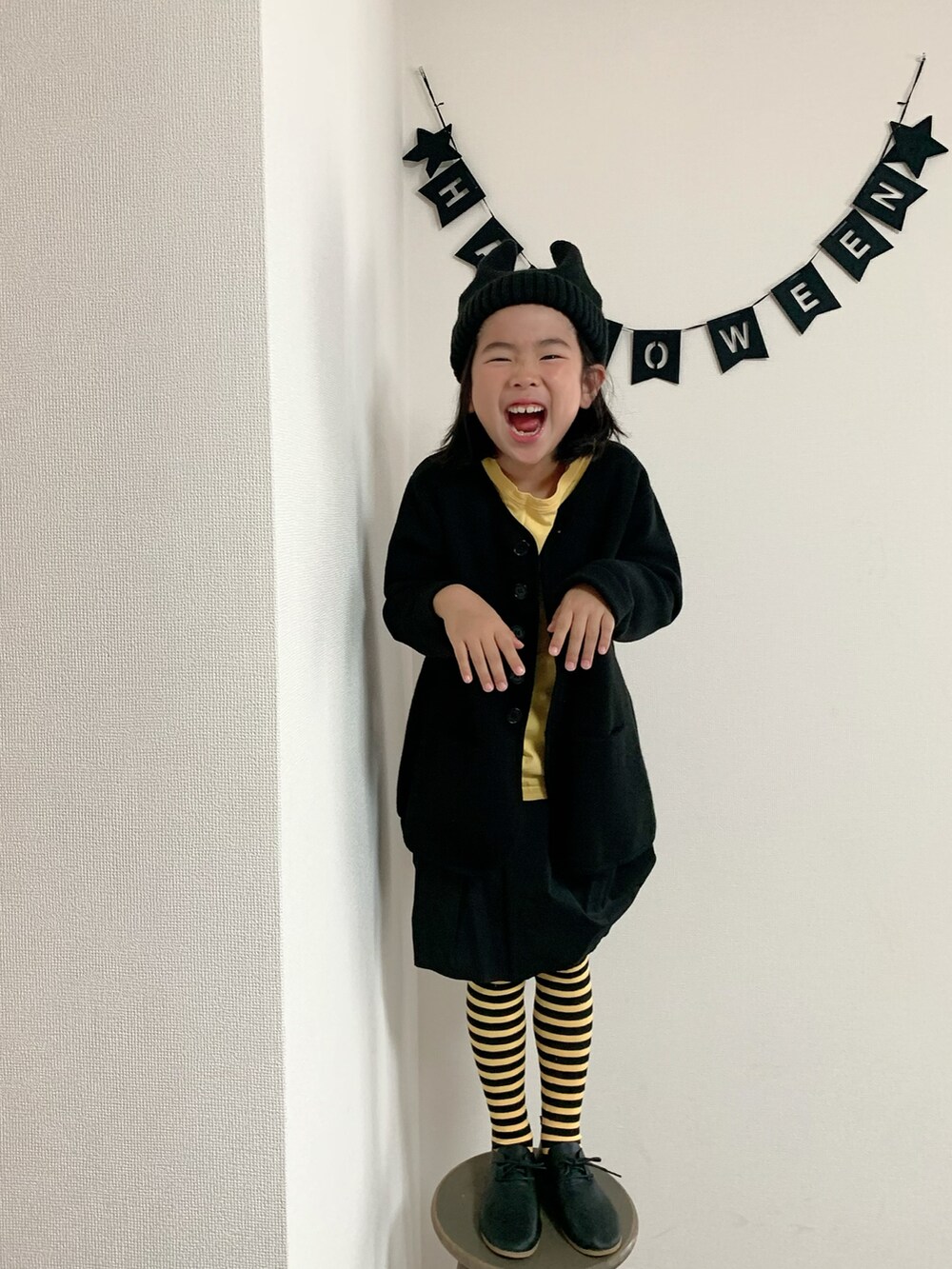 ブラック系のニット/セーター、ブラック系のシューズ、イエロー系のタイツ/ストッキングを着用したキッズの秋コーディネートの2枚目の写真