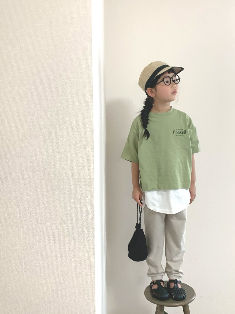 ブラック系のサンダル、ベージュ系のスウェットパンツ、グリーン系のTシャツ/カットソーを着用したキッズの春コーディネートの2枚目の写真