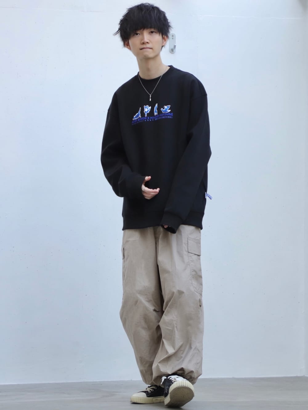 ブラック系のスウェット、ベージュ系のカーゴパンツ、ブラック系のスニーカーを着用したメンズの冬コーディネートの2枚目の写真