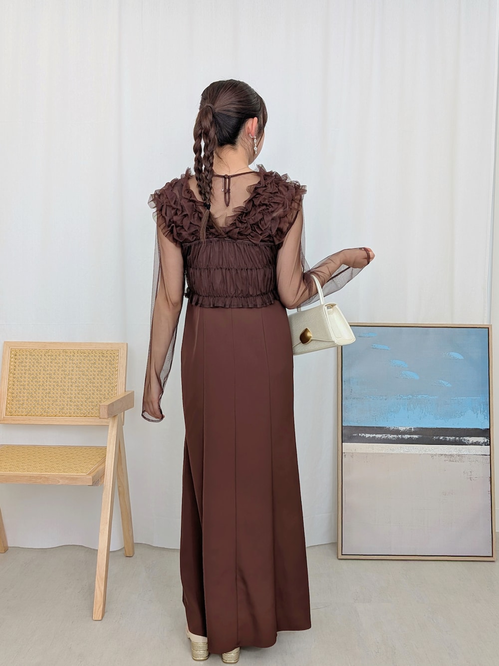 ブラウン系のドレスを着用したレディースの冬コーディネートの2枚目の写真