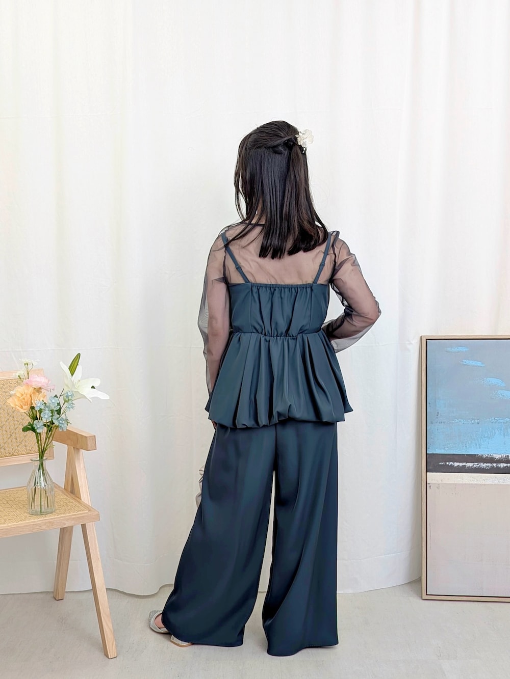 シルバー系のハンドバッグ、ブルー系のパンツドレスを着用したレディースの春コーディネートの3枚目の写真