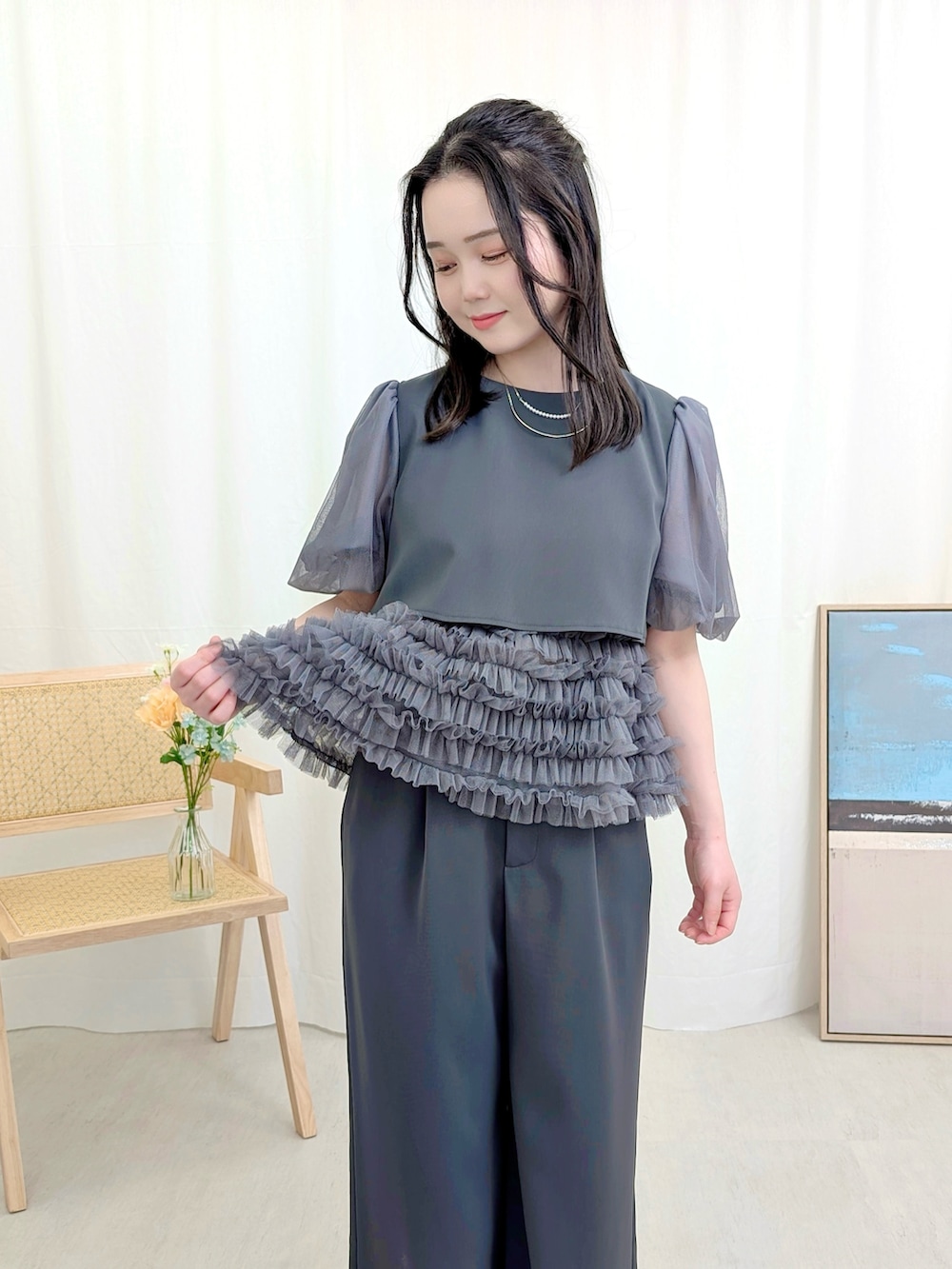 グレー系のパンツドレス、シルバー系のハンドバッグ、シルバー系のパンプスを着用したレディースの春コーディネートの2枚目の写真
