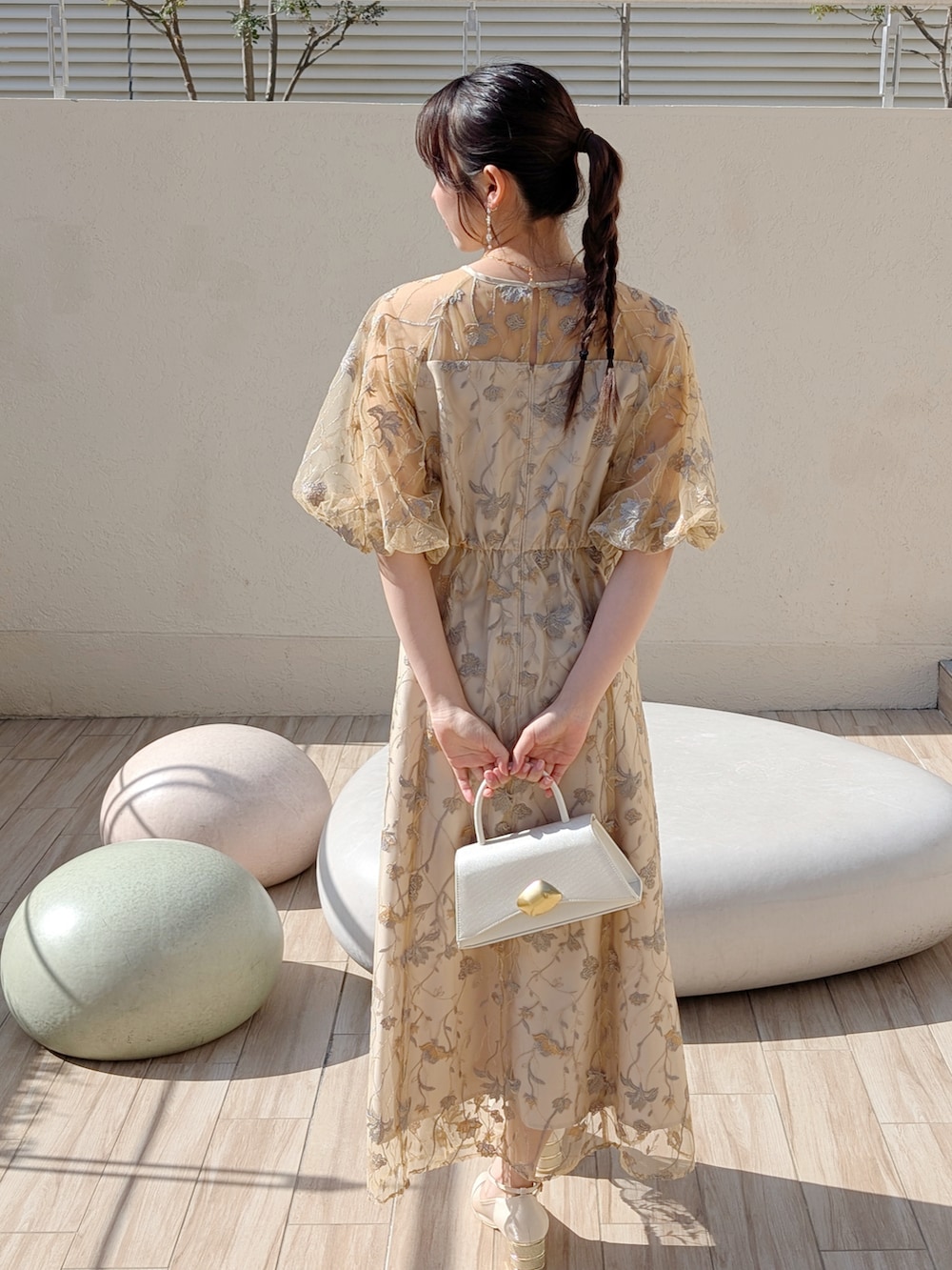 シルバー系のパンプス、イエロー系のドレスを着用したレディースの冬コーディネートの2枚目の写真