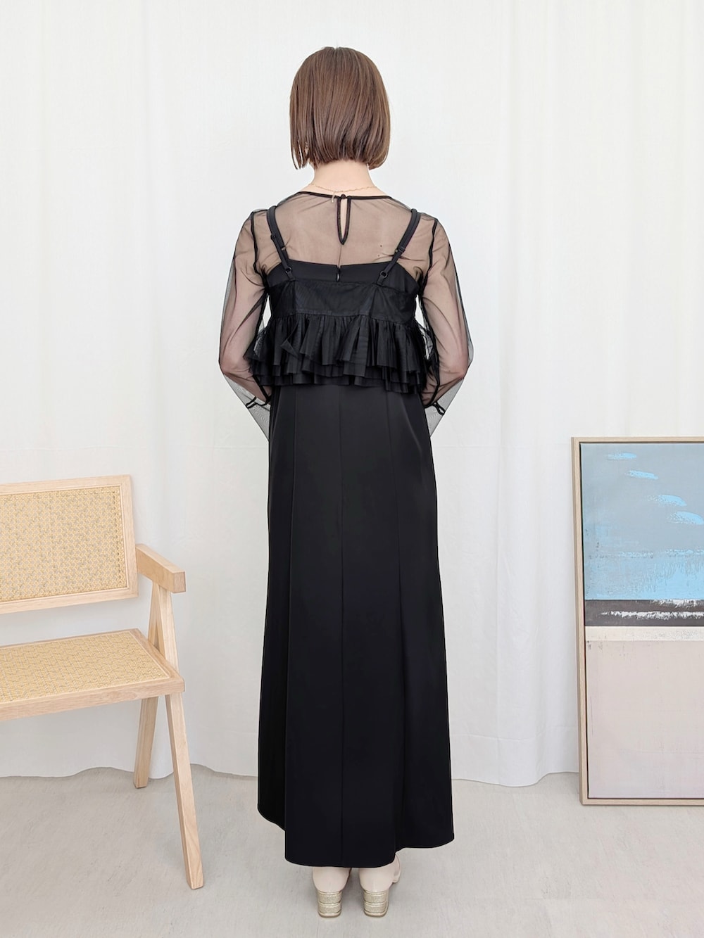 シルバー系のパンプス、ブラック系のドレスを着用したレディースの冬コーディネートの2枚目の写真