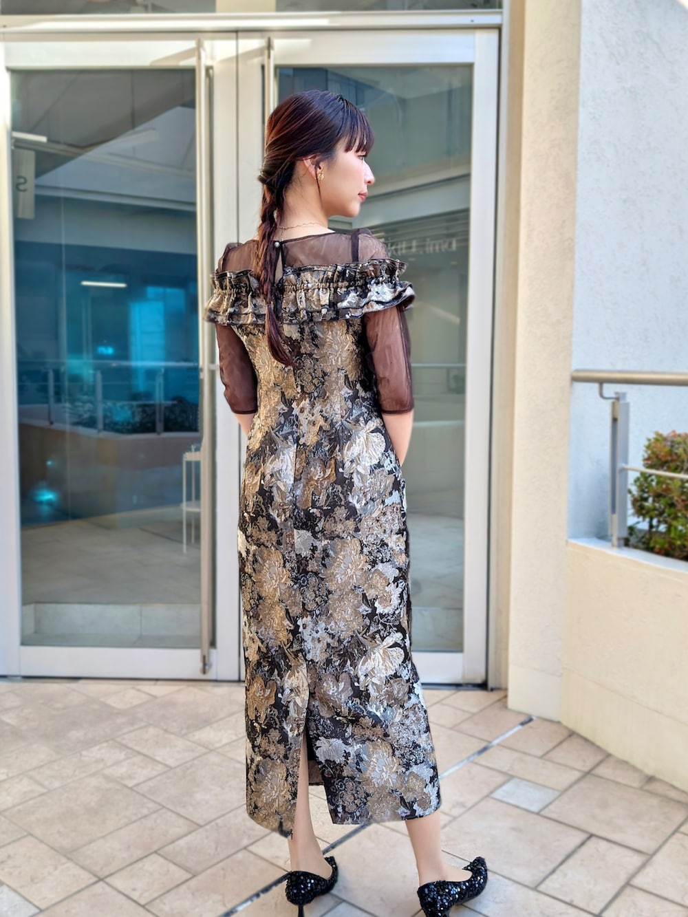 ゴールド系のハンドバッグ、ブラウン系のドレスを着用したレディースの春コーディネートの2枚目の写真