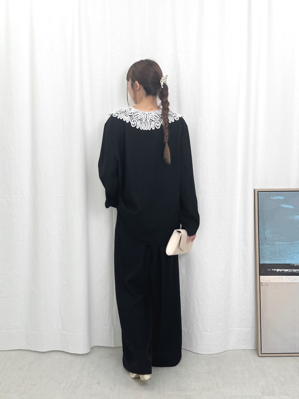 ブラック系のパンツドレスを着用したレディースの秋コーディネートの2枚目の写真
