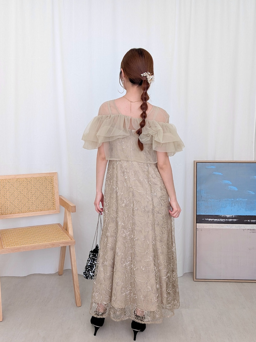 ブラック系のハンドバッグ、ベージュ系のドレスを着用したレディースの春コーディネートの2枚目の写真