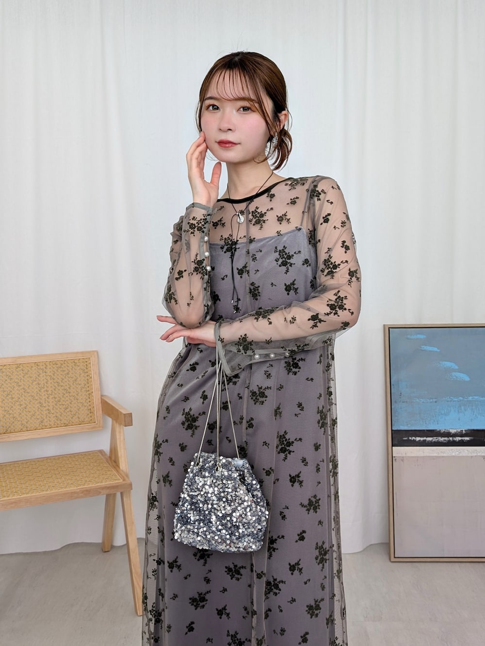 グリーン系のドレス、シルバー系のハンドバッグ、シルバー系のネックレスを着用したレディースの冬コーディネートの3枚目の写真