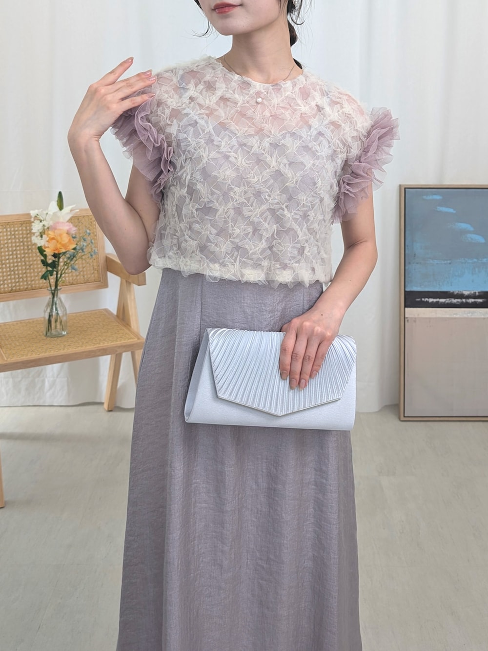 パープル系のドレス、シルバー系のパンプス、シルバー系のクラッチバッグを着用したレディースの春コーディネートの3枚目の写真