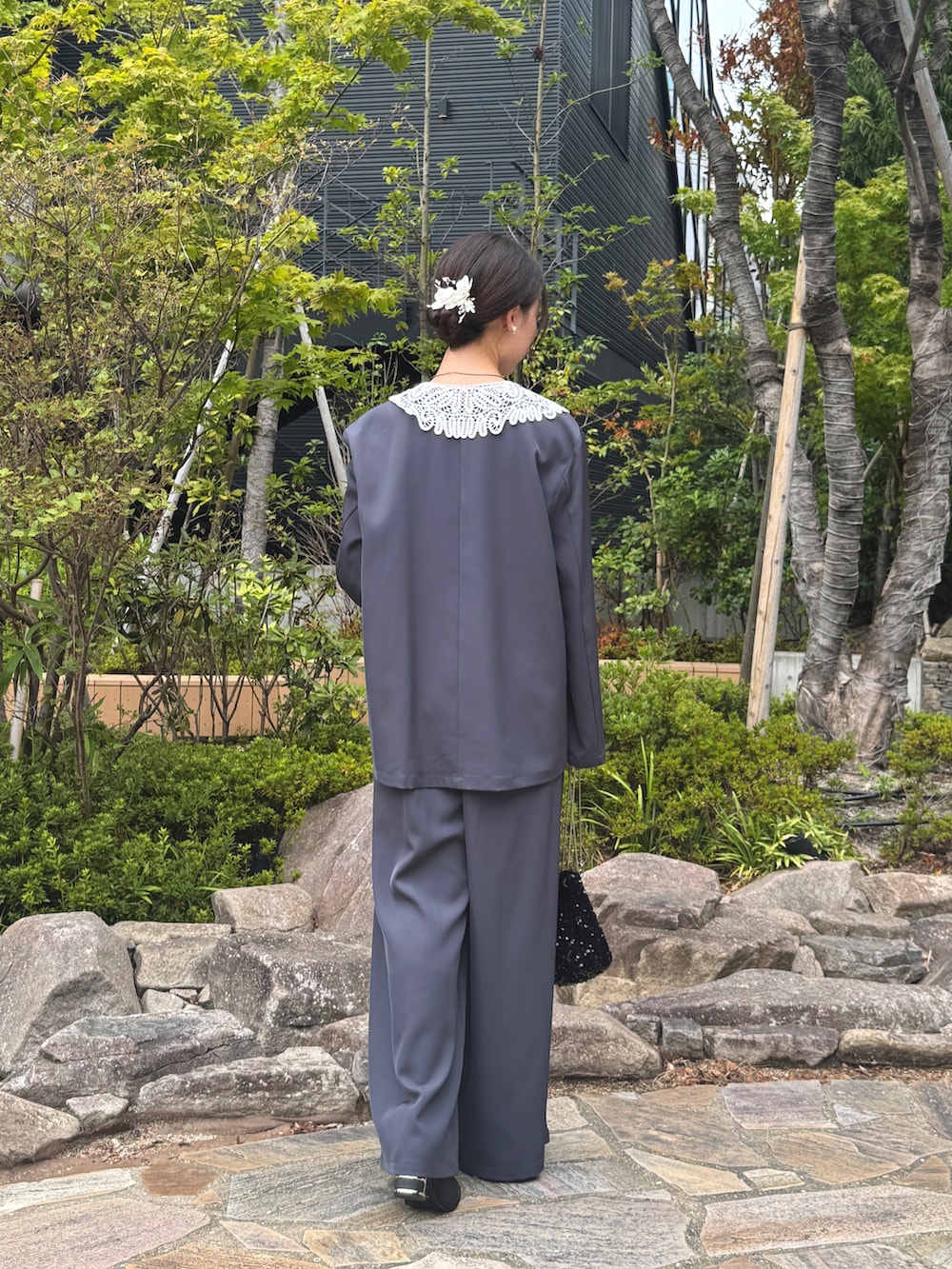 ブルー系のパンツドレス、ブラック系のハンドバッグを着用したレディースの秋コーディネートの2枚目の写真