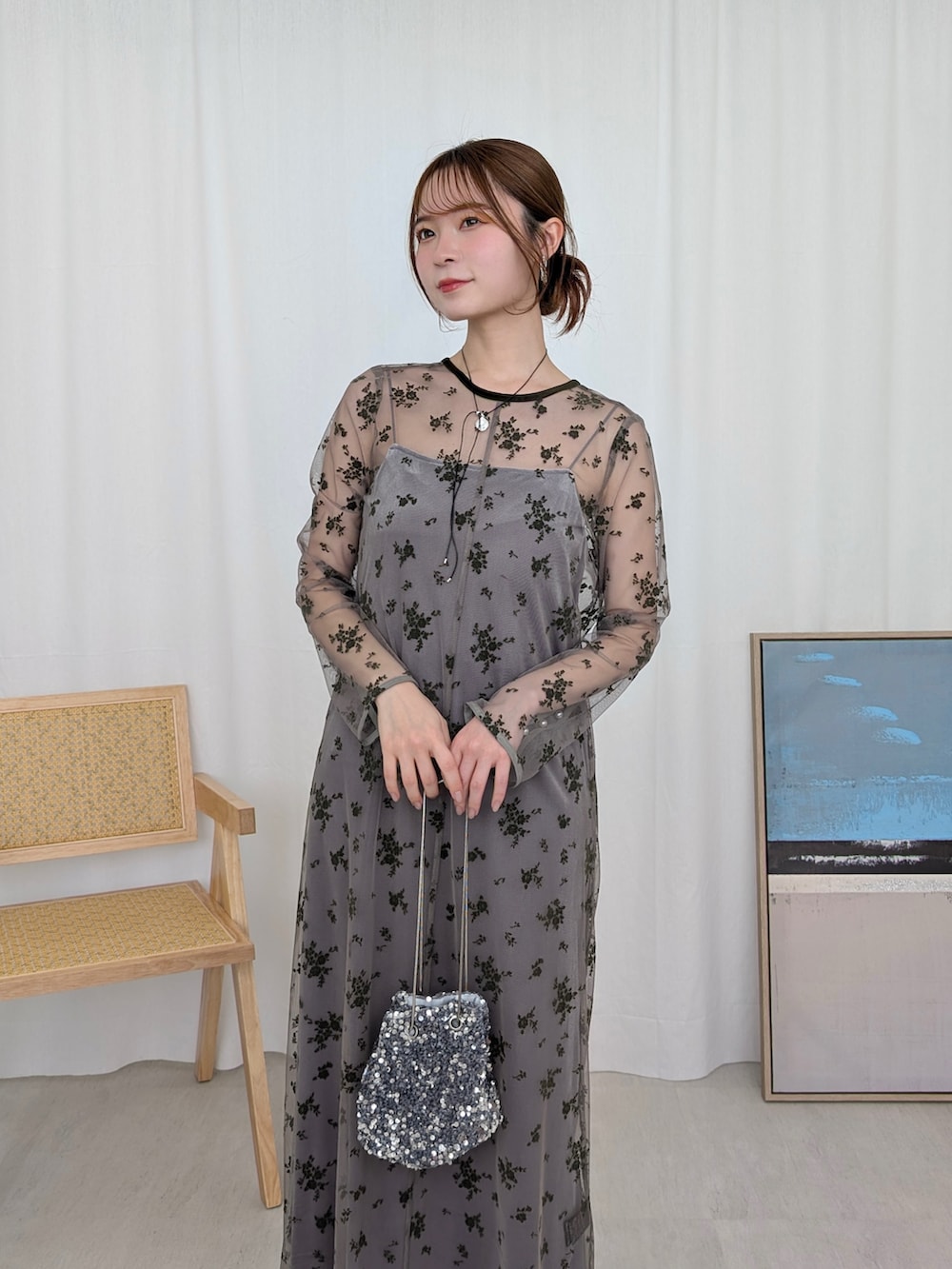 グリーン系のドレス、シルバー系のハンドバッグ、シルバー系のネックレスを着用したレディースの冬コーディネートの4枚目の写真