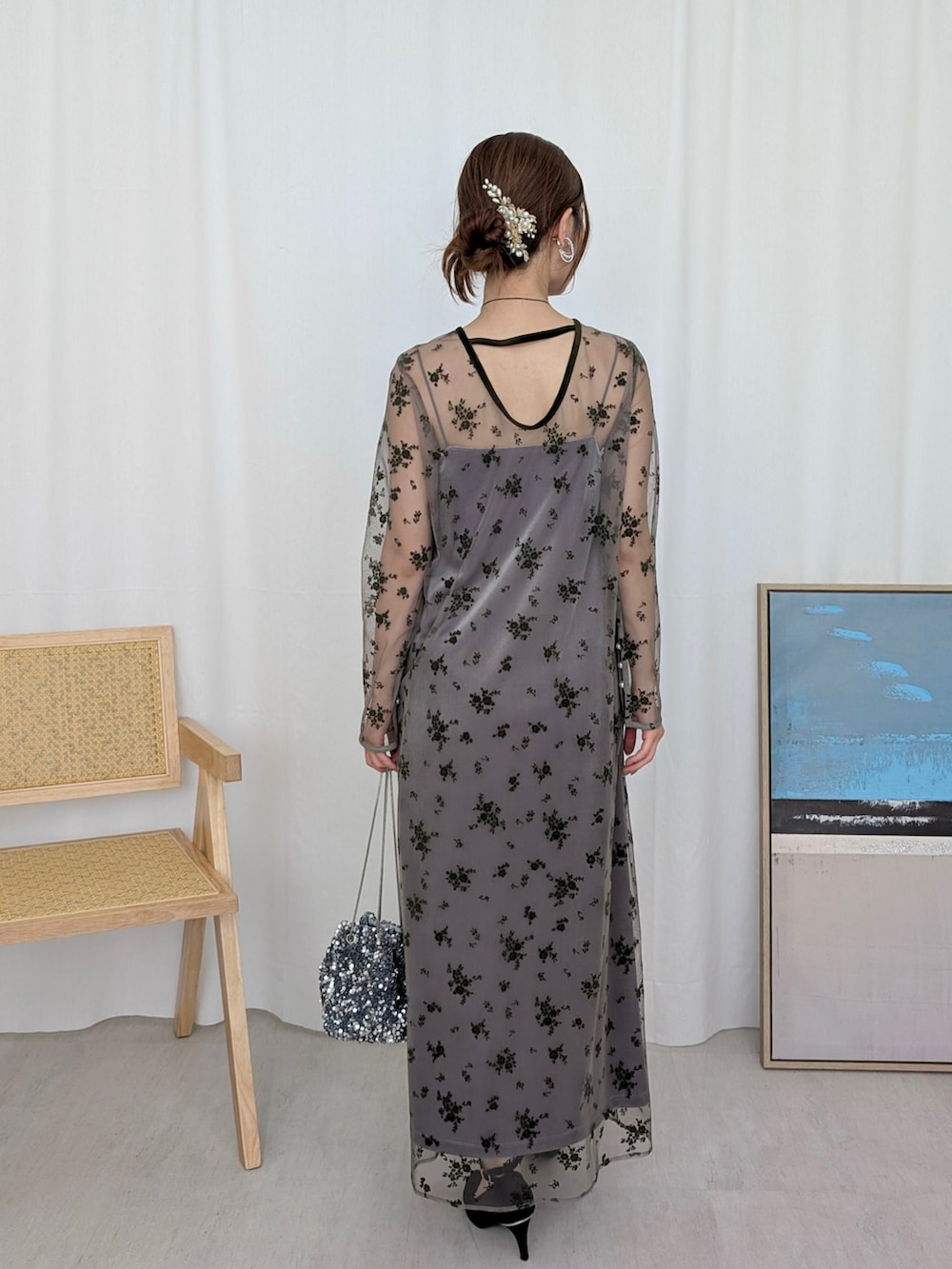 グリーン系のドレス、シルバー系のハンドバッグ、シルバー系のネックレスを着用したレディースの冬コーディネートの2枚目の写真