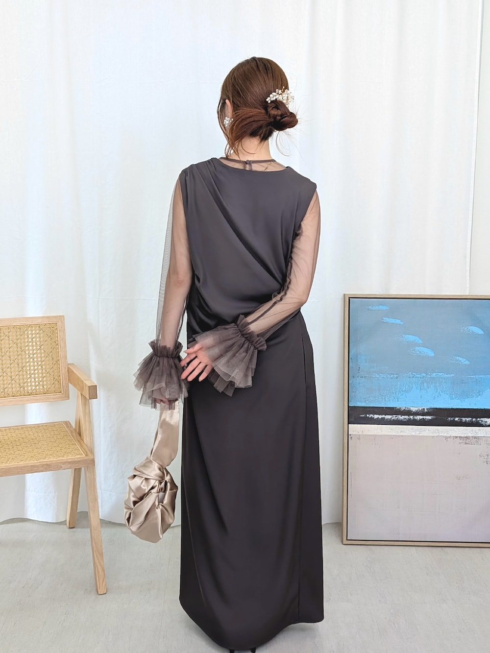 グレー系のドレス、ゴールド系のハンドバッグを着用したレディースの春コーディネートの3枚目の写真