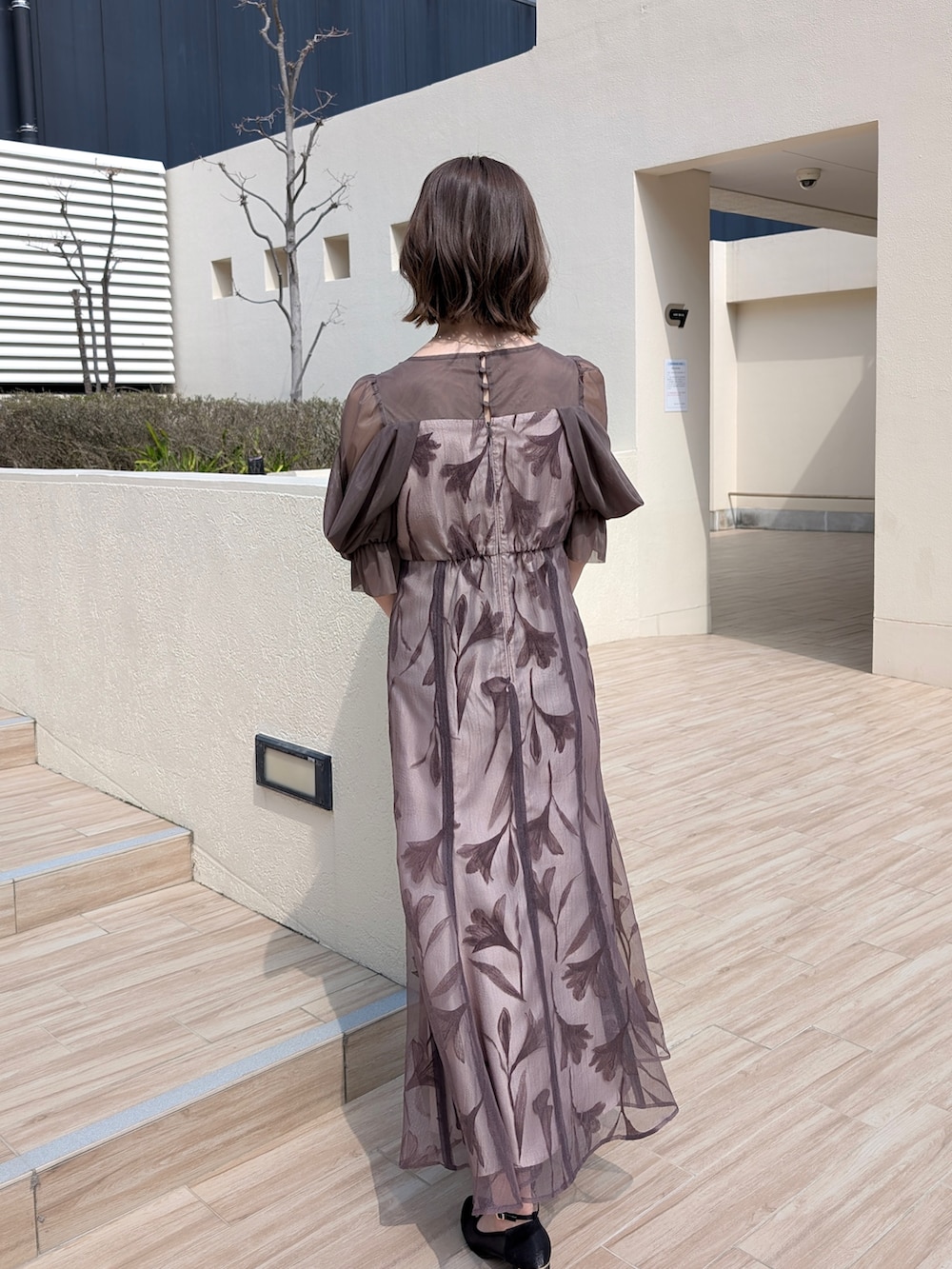 ブラウン系のドレス、ブラック系のパンプス、オレンジ系のワンピース/ドレスを着用したレディースの春コーディネートの3枚目の写真