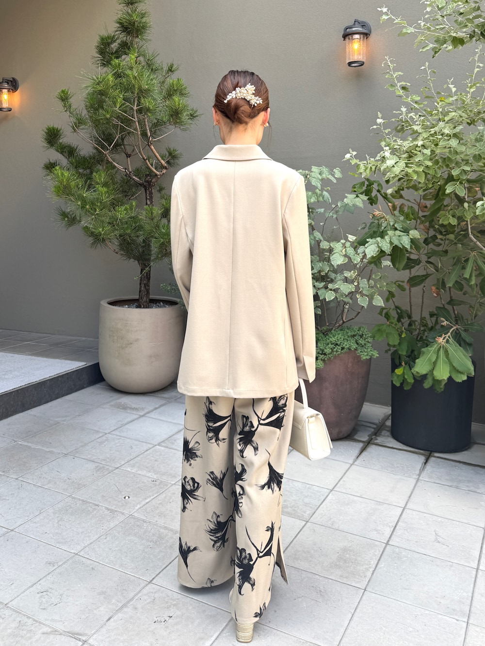 ベージュ系のパンプス、ベージュ系のパンツドレス、ベージュ系のバッグを着用したレディースの夏コーディネートの2枚目の写真