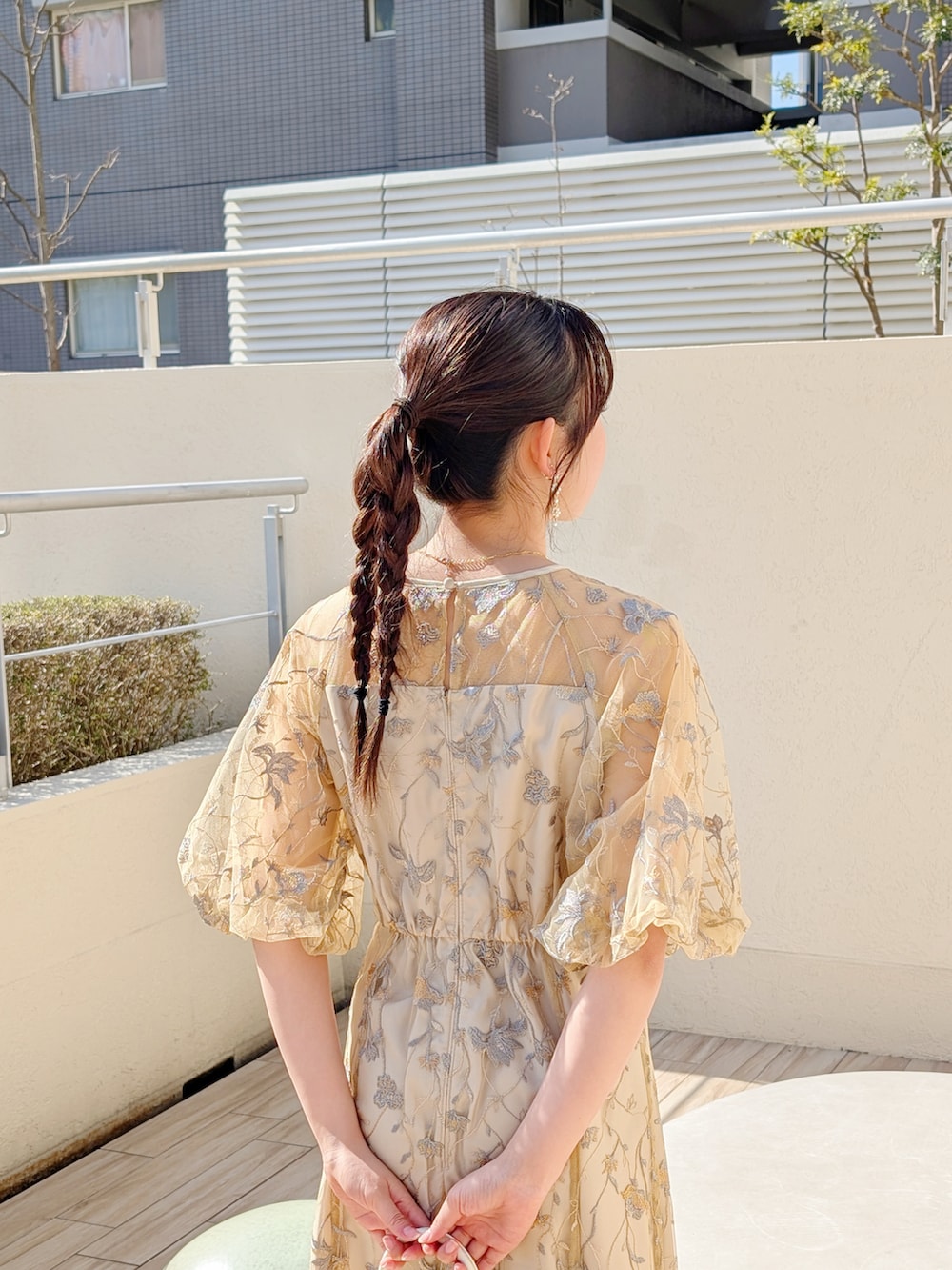 シルバー系のパンプス、イエロー系のドレスを着用したレディースの冬コーディネートの3枚目の写真